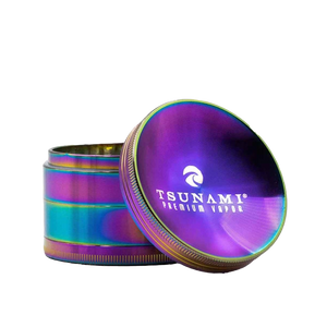 A 63mm Tsunami herb grinder with a distinctive caved top, showing its diamond-cut teeth and four-piece chamber design.